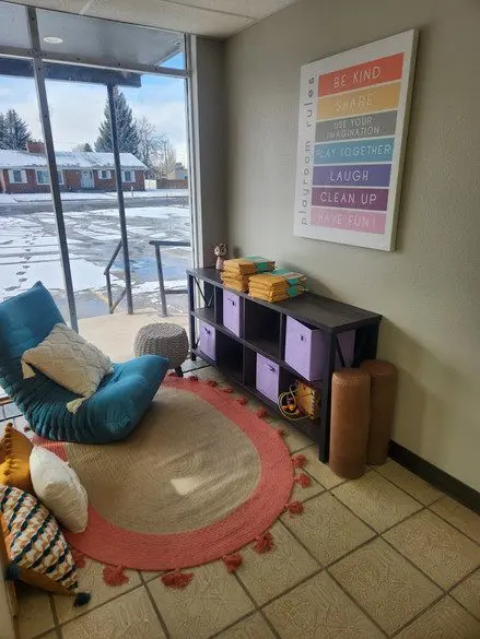 A room with a large window and a colorful rug.