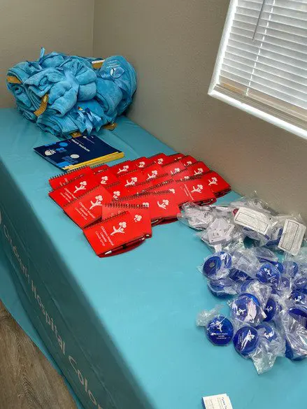 A table with blue cloth and many bags of food