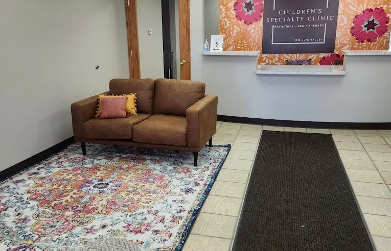 A couch and rug in the lobby of an office building.