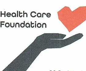 A hand holding a paper heart with the words health care foundation underneath it.